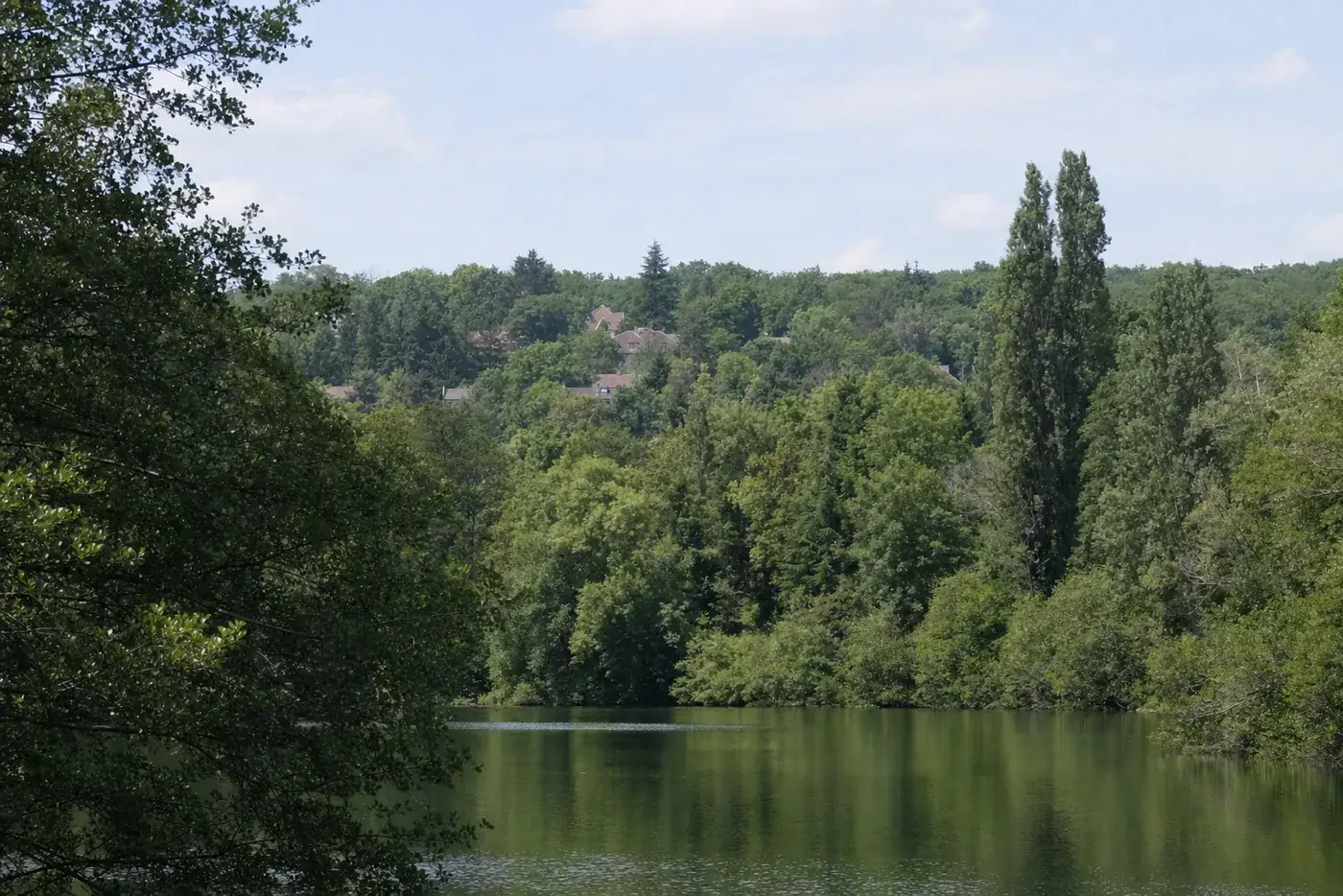 Plan d'eau bordé de bois et de maisons sur les coteaux des Yvelines (visuel d'illustration)
